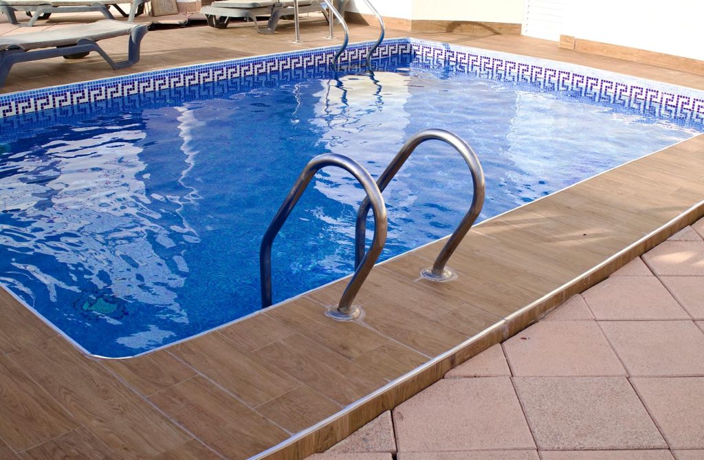 Communal rooftop swimming pool with sun loungers